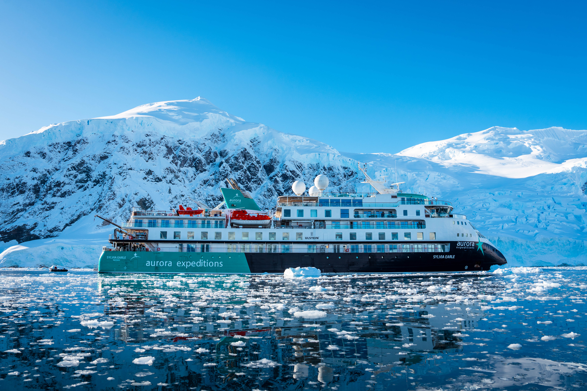 Aurora Expeditions Vessel in Antarctic Waters An expedition cruise ship navigating through icy waters with snow-capped mountains and glaciers