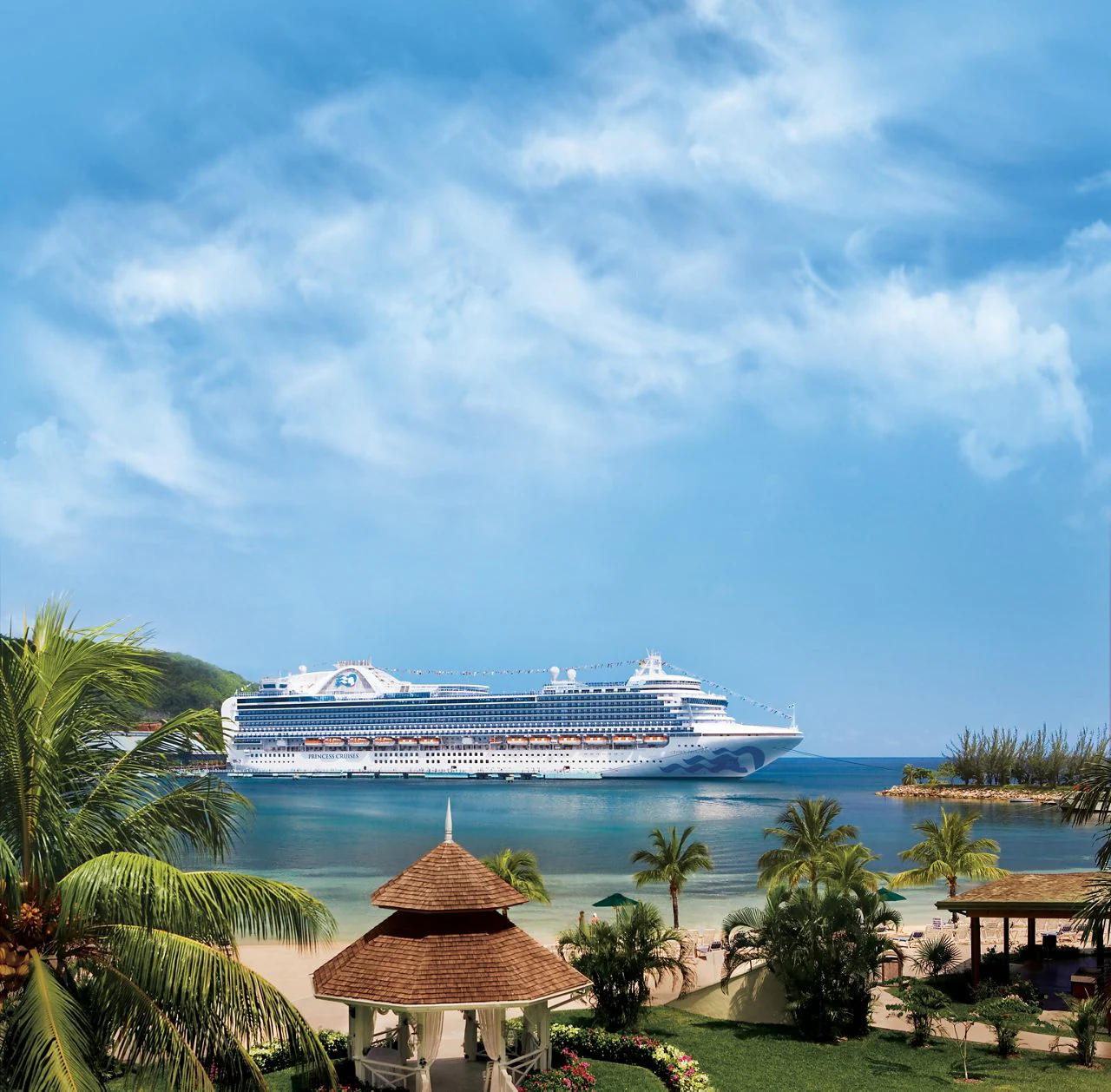 Caribbean Cruise Ship at Tropical Resort A large white Princess Cruises ship anchored in a beautiful turquoise bay with a tropical beach