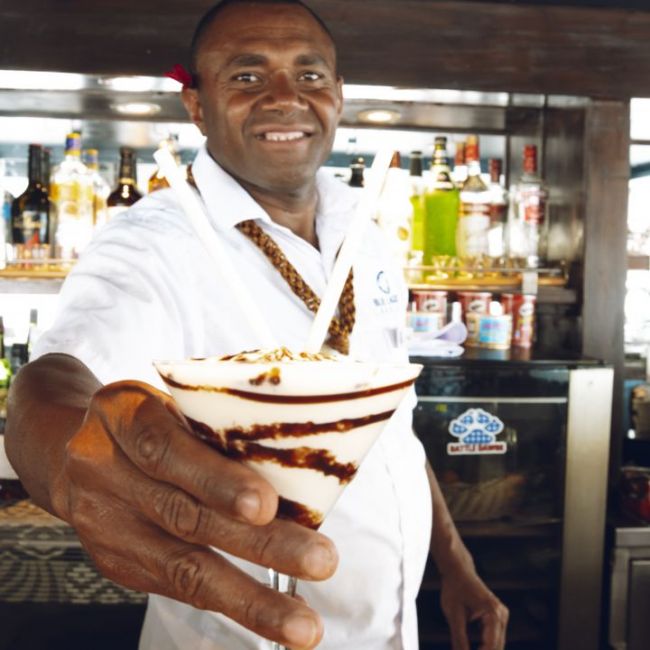 Chef Presenting Culinary Creation Onboard A smiling chef in white chef's coat presents an elegantly plated dessert with chocolate drizzle