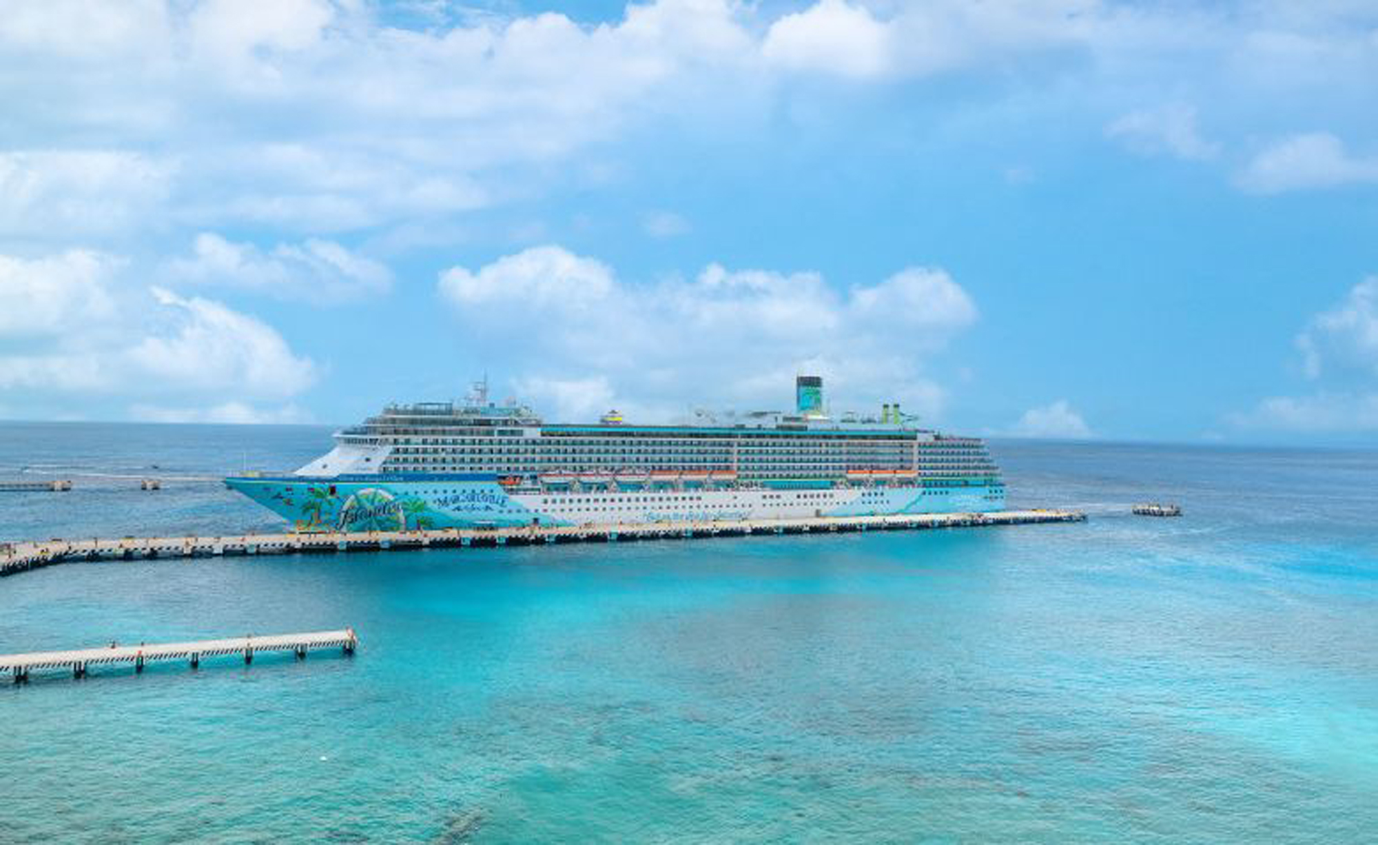 Colorful Margaritaville at Sea cruise ship docked at tropical Caribbean port with turquoise waters