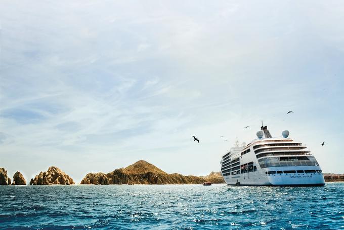 Cruise Ship Near Rocky Coastal Landscape A pristine white cruise ship anchored near rugged rocky islands with turquoise blue waters and