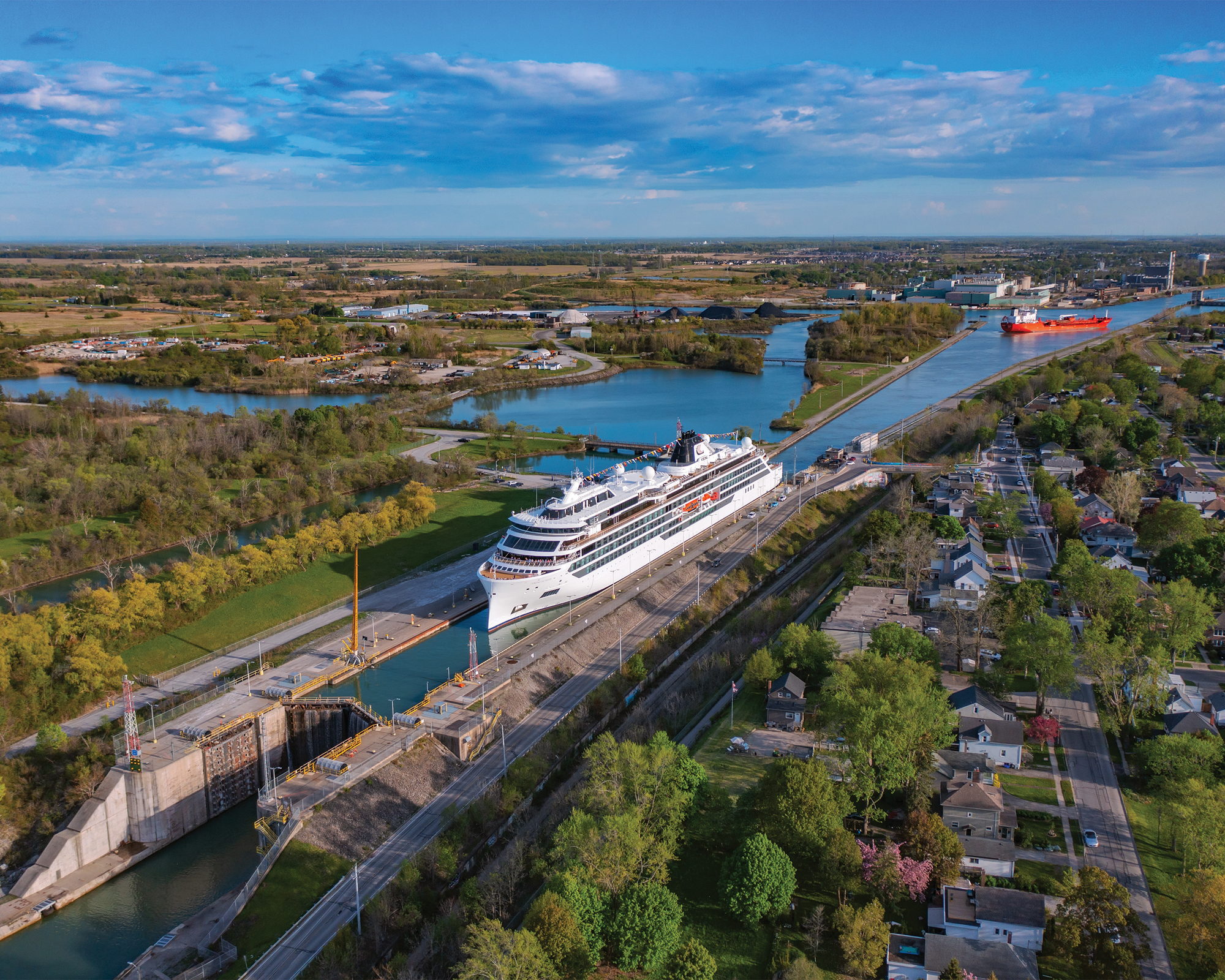 Cruise Ship Passing Through Canal Lock An aerial view of a large white cruise ship navigating through a narrow canal lock, surrounded