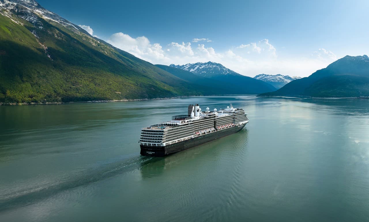 Cruise Ship in Alaskan Mountain Fjord A modern cruise ship sailing through a serene fjord surrounded by lush green mountains