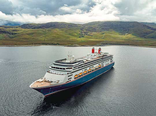 Cruise Ship in Icelandic Waters A large modern cruise ship with distinctive red and blue hull markings anchors in calm waters off