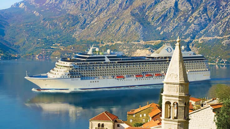Cruise Ship in Scenic Mountain Fjord A large white cruise ship sailing through a stunning coastal landscape with dramatic mountain