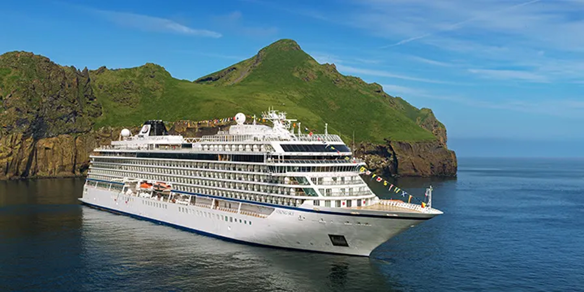 Cruise Ship in Scenic Volcanic Landscape Viking cruise ship sailing near a green mountainous volcanic island