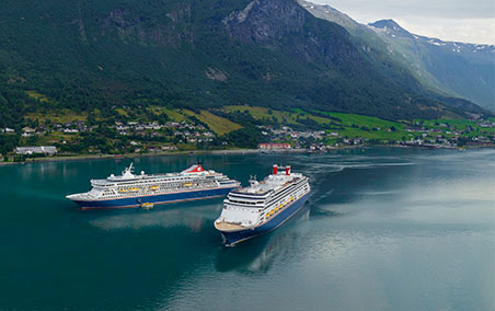 Cruise Ships Anchored in Norwegian Fjord Two large cruise ships are anchored in a pristine turquoise fjord surrounded by dramatic