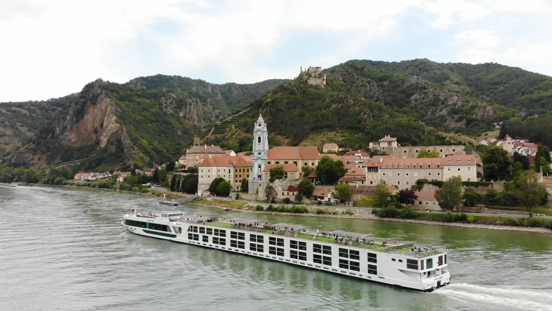 Danube River Cruise in Historic European Landscape Scenic river cruise ship sailing along the Danube past a picturesque historic town