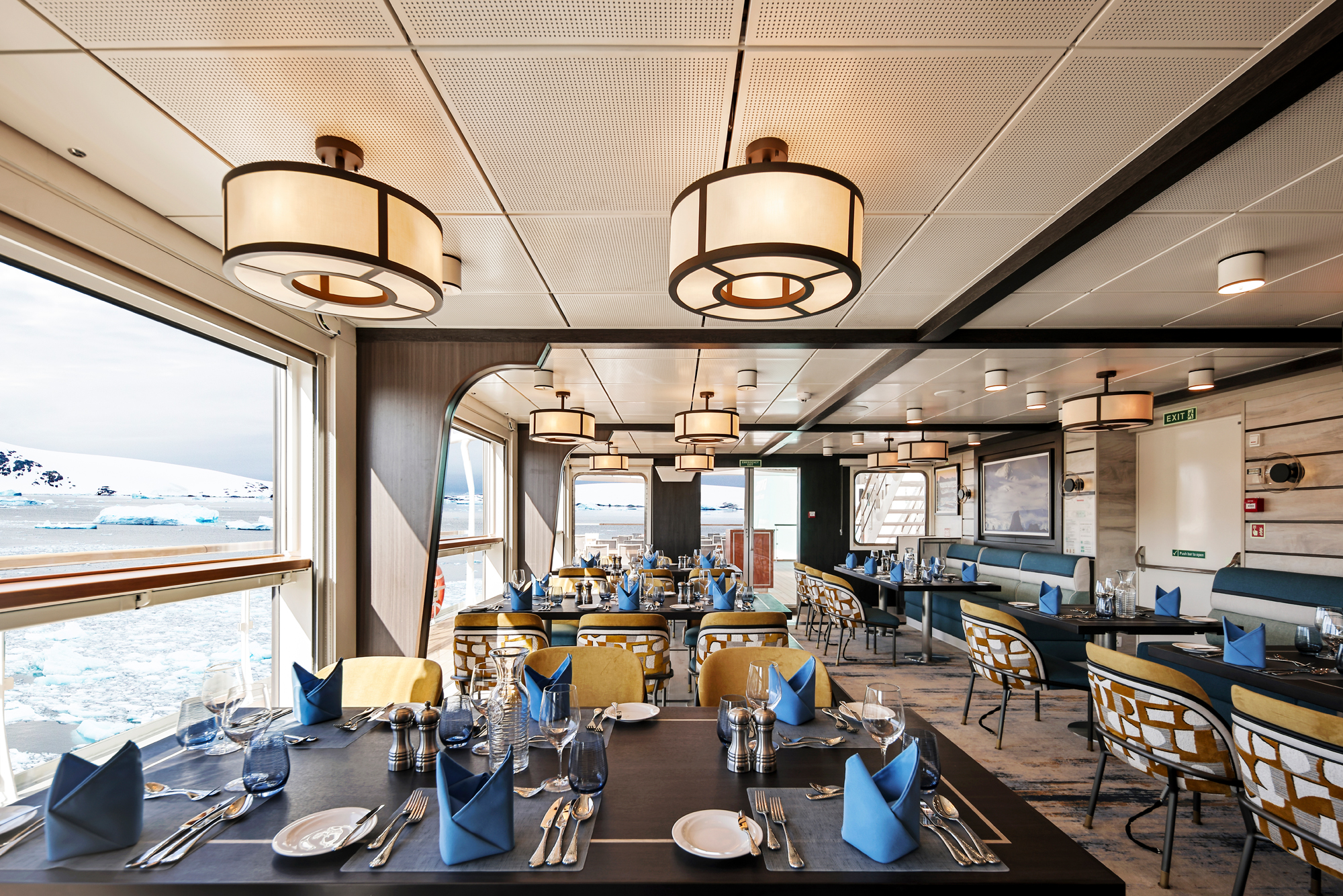 Expedition Cruise Dining Room with Polar Landscape An elegant dining area on an expedition cruise ship featuring large windows overlooking an icy