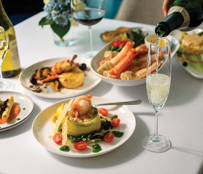Fine Dining Experience with Sparkling Wine Service An elegant dining scene showcasing a multi-course plated meal with fresh seafood, vegetables