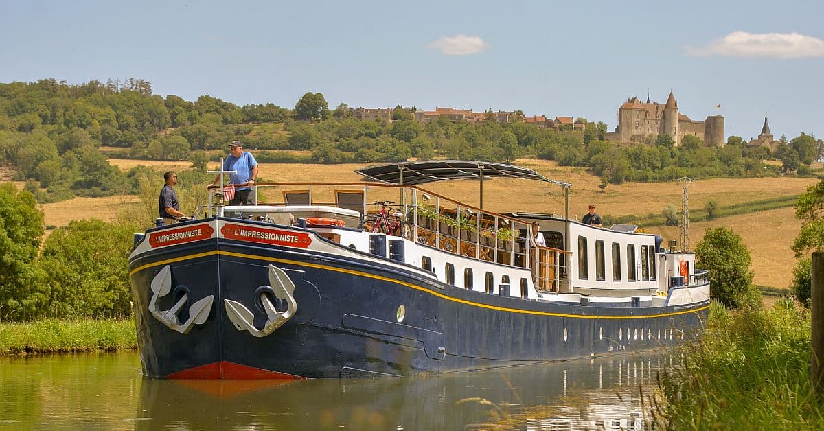 L’Impressionniste Barge on European Waterway A traditional European river barge named L'Impressionniste navigates a peaceful canal