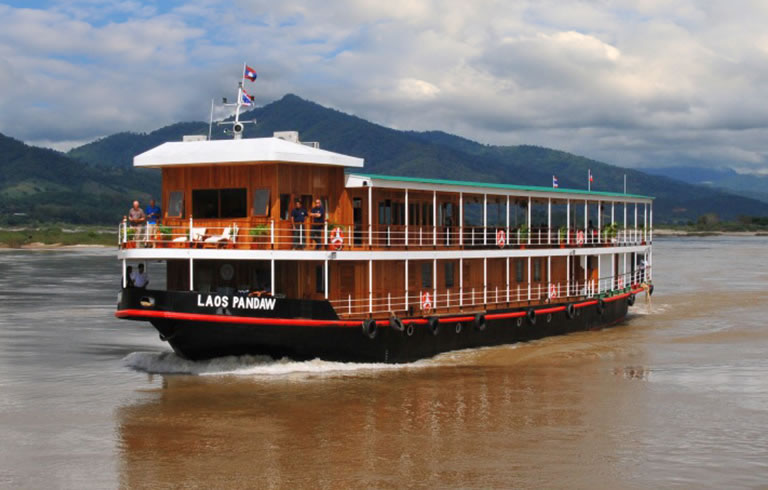 Laos Pandaw river cruise ship navigating the Mekong River with mountainous landscape