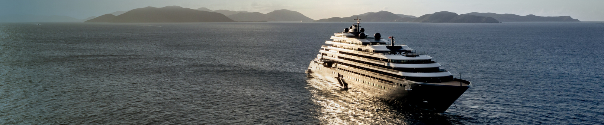 Luxurious Superyacht at Scenic Mountain Coast Ritz-Carlton luxury yacht sailing along a scenic mountain coastline