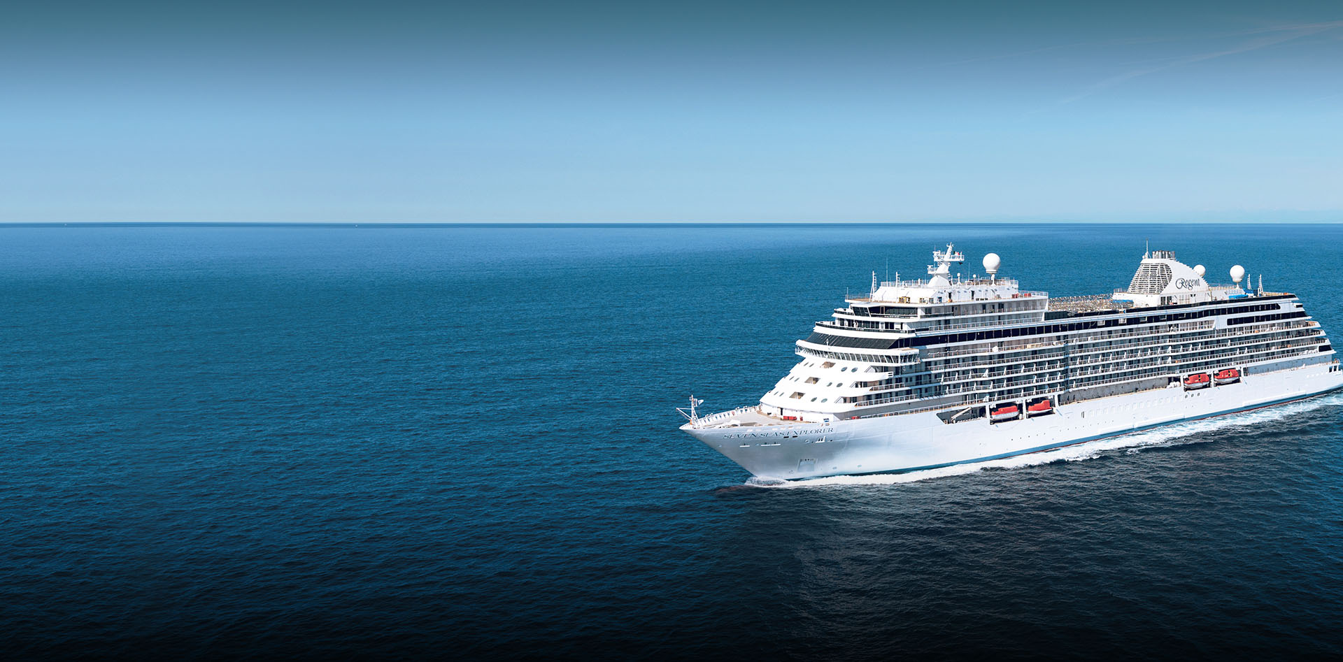 Luxury Cruise Ship Sailing Blue Ocean Regent Seven Seas cruise ship sailing across tranquil blue ocean