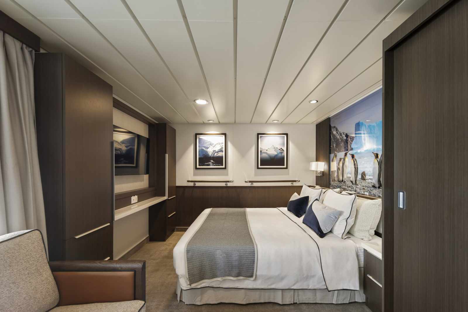 Luxury Cruise Ship Stateroom with Polar Imagery An elegantly designed cruise ship cabin featuring modern minimalist decor with recessed lighting