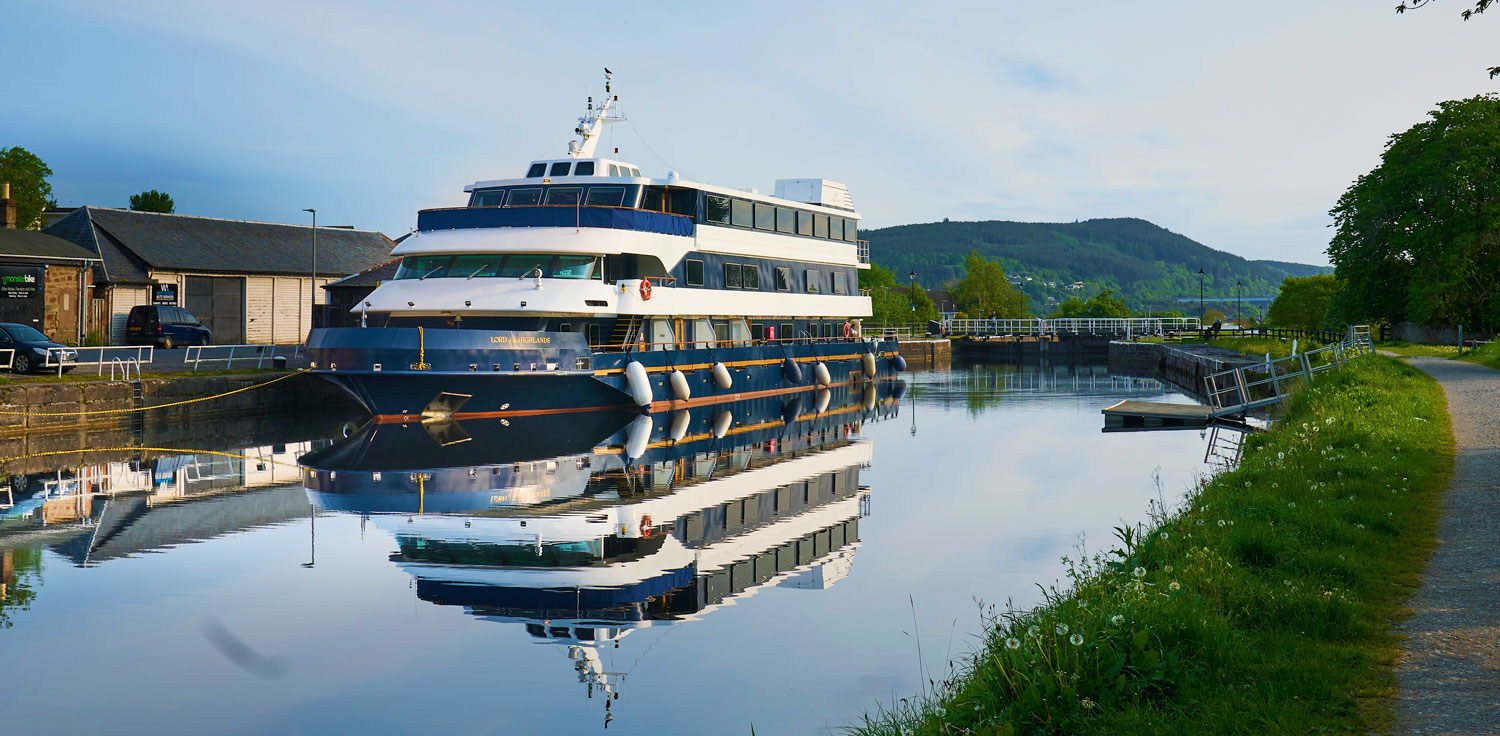 Luxury River Cruise Vessel at Dock A multi-deck luxury river cruise ship moored at a peaceful inland waterway, featuring distinctive