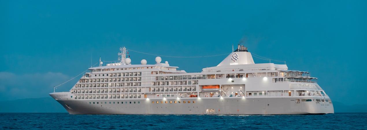 Luxury White Cruise Ship at Sea A pristine white cruise ship sailing on calm blue waters with a clear turquoise sky in