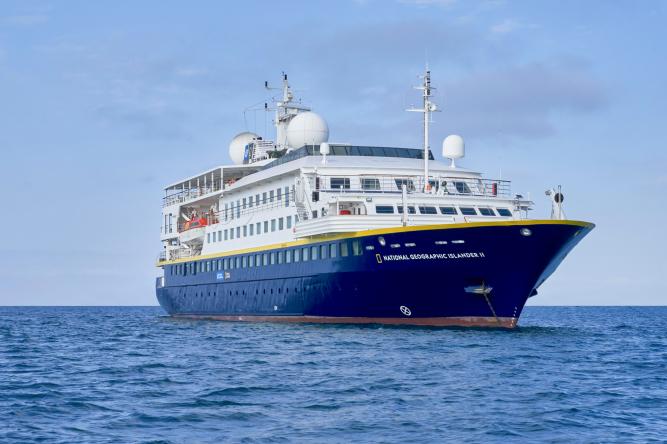 National Geographic Lindblad Cruise Ship at Sea National Geographic expedition cruise ship with blue hull sailing on calm waters