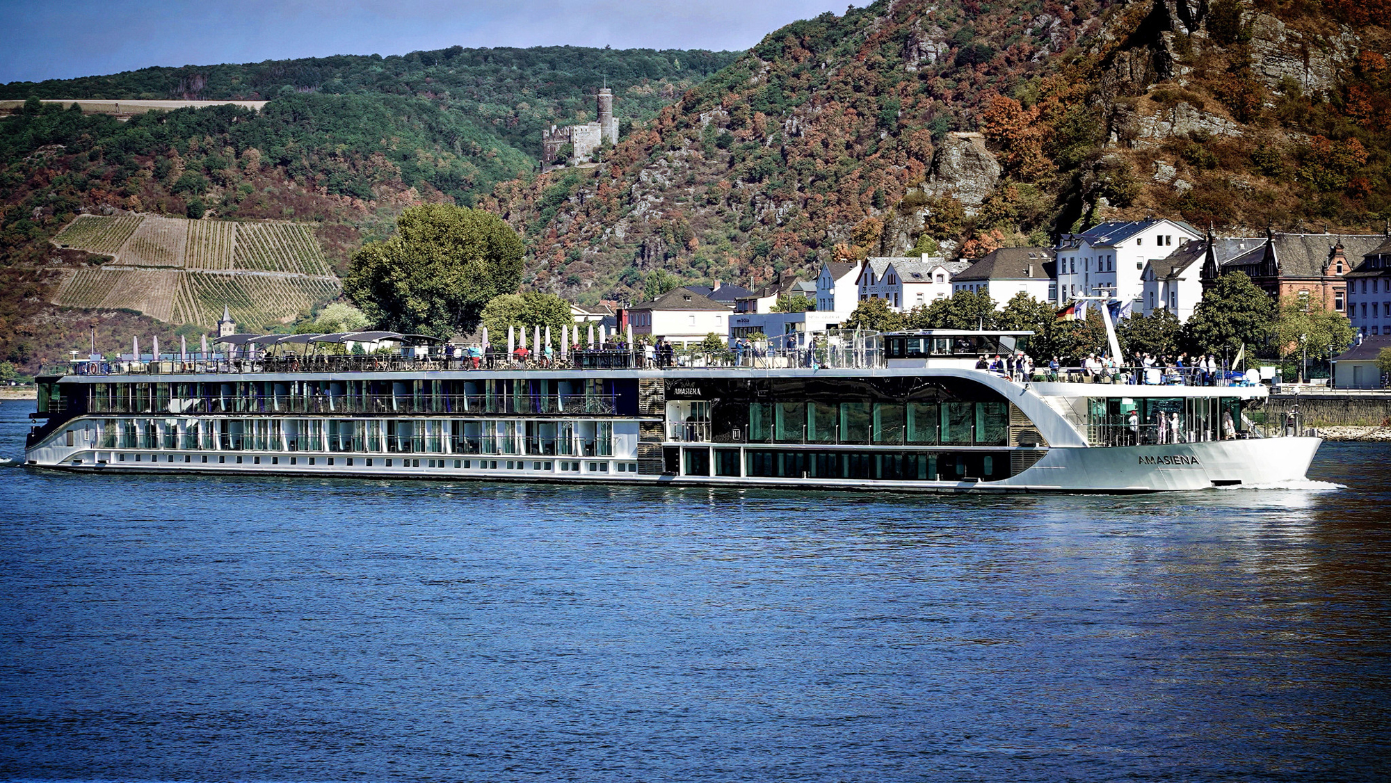 River Cruise Ship on Moselle River, Germany A modern river cruise ship named Amasiena docked along a picturesque riverside town with vineyards