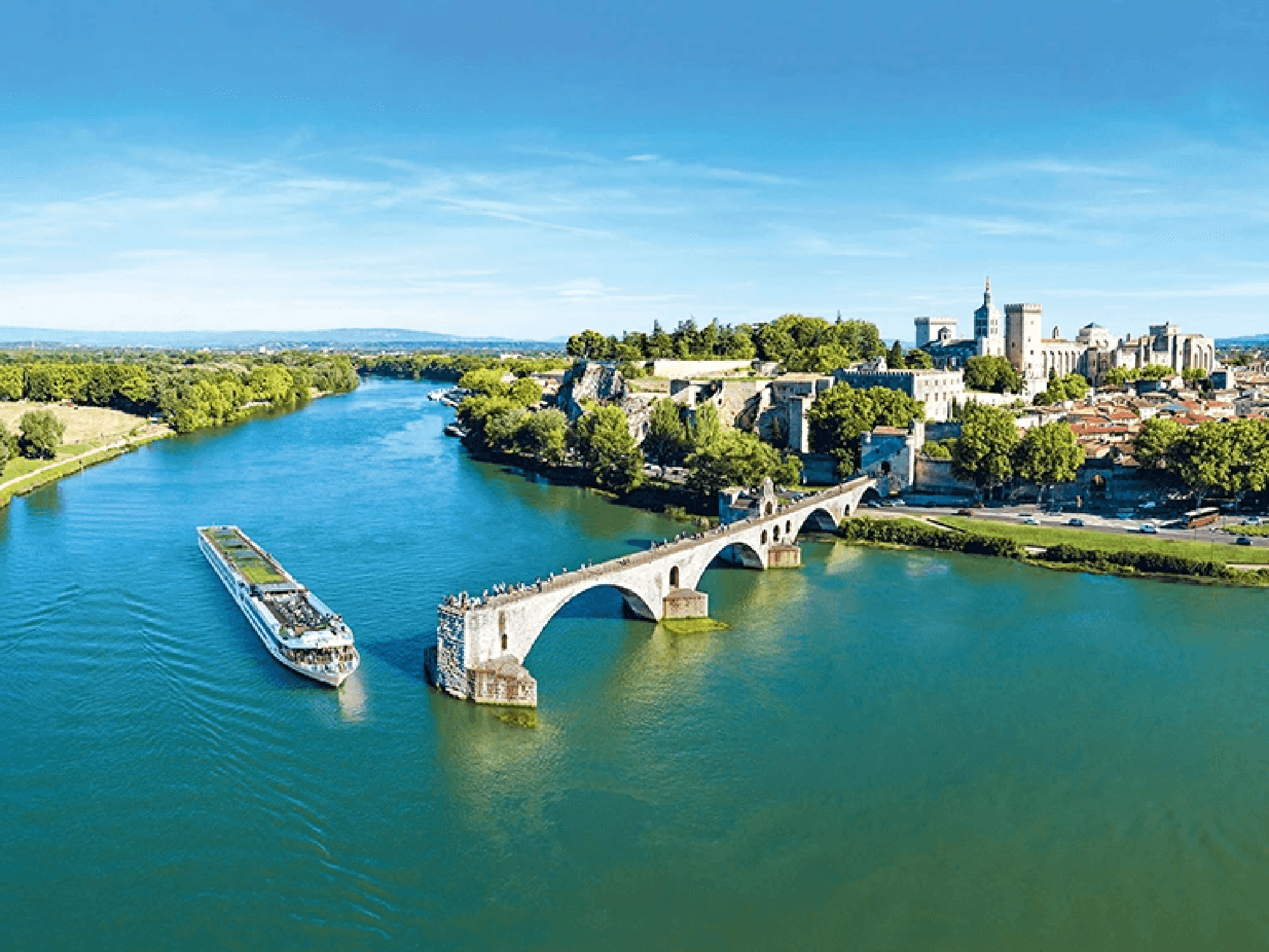 Scenic River Cruise in Avignon, France River cruise ship near the historic Pont d'Avignon with the medieval city in the background