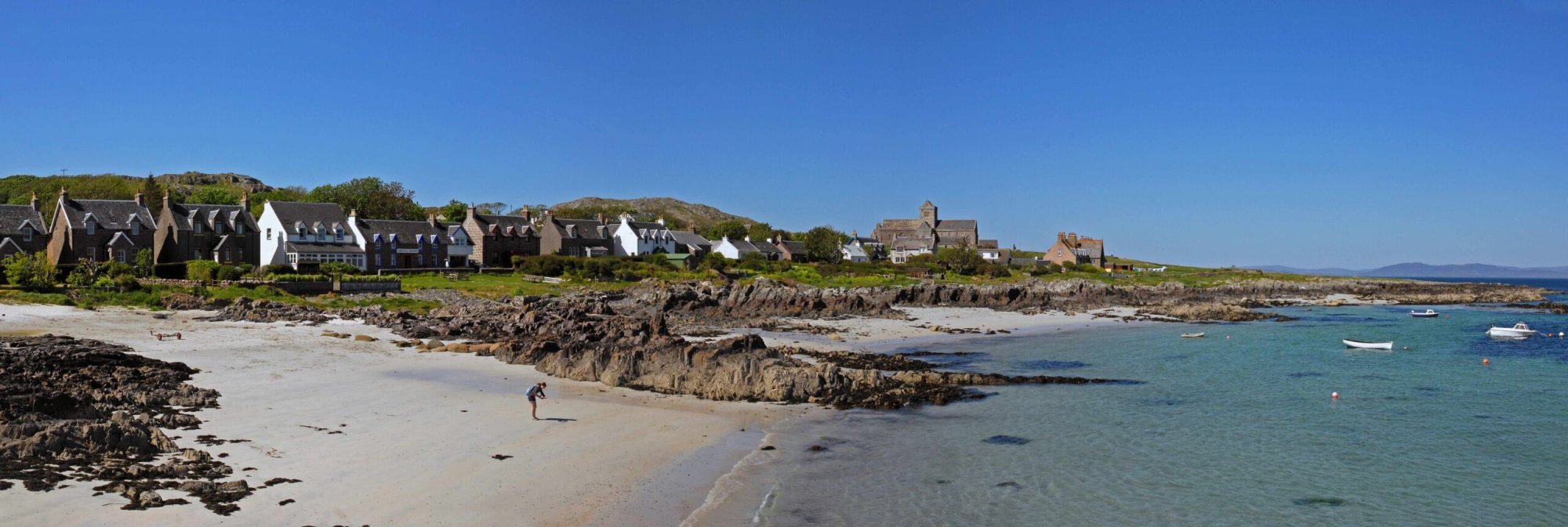 Scottish Coastal Village with Beach and Boats A picturesque Scottish coastal settlement featuring traditional stone architecture with distinctive