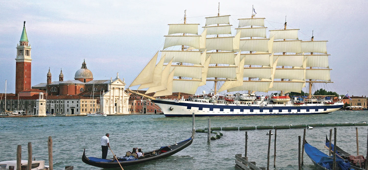 Tall Ship in Venice Harbor Royal Clipper tall ship sailing through Venice lagoon with gondolas in foreground