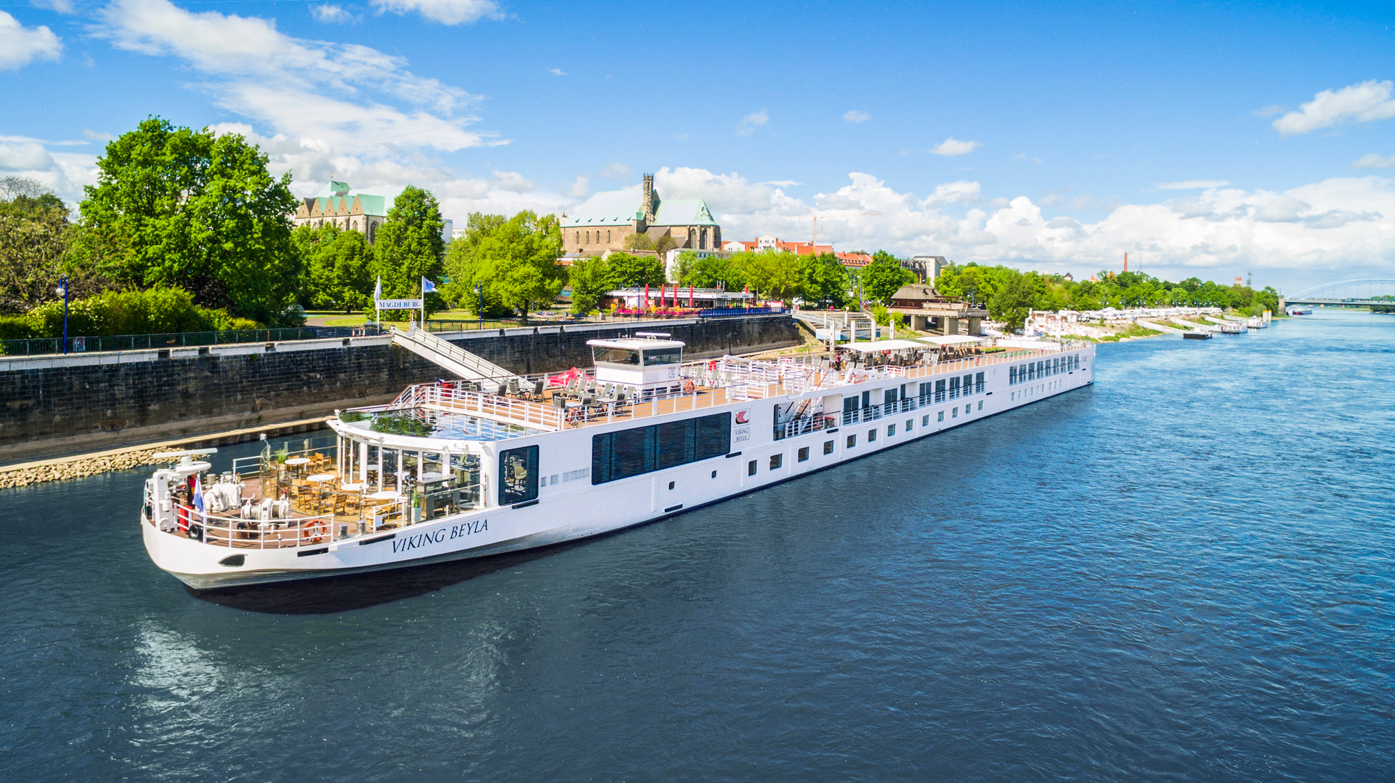 Viking River Cruise Ship in European Port A white Viking river cruise ship docked in a scenic European city, with lush green trees