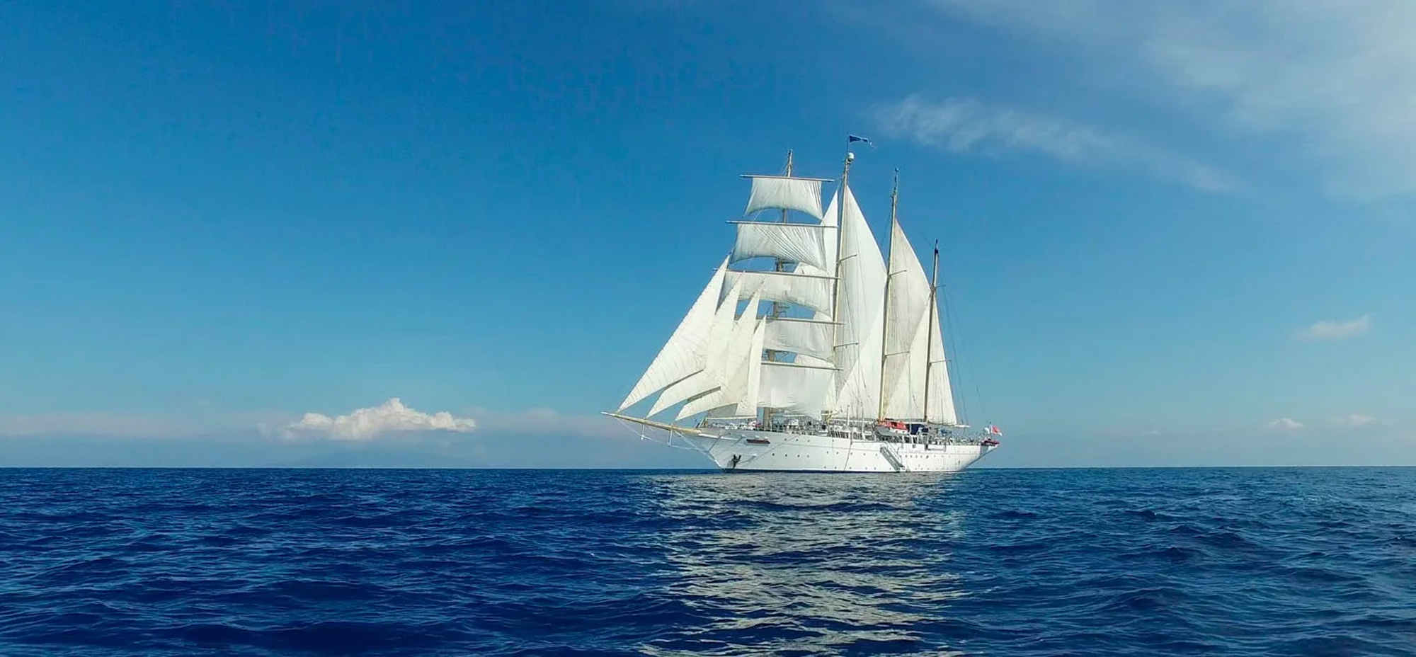 White Sailing Ship on Blue Ocean Star Clippers tall ship under full sail on blue ocean