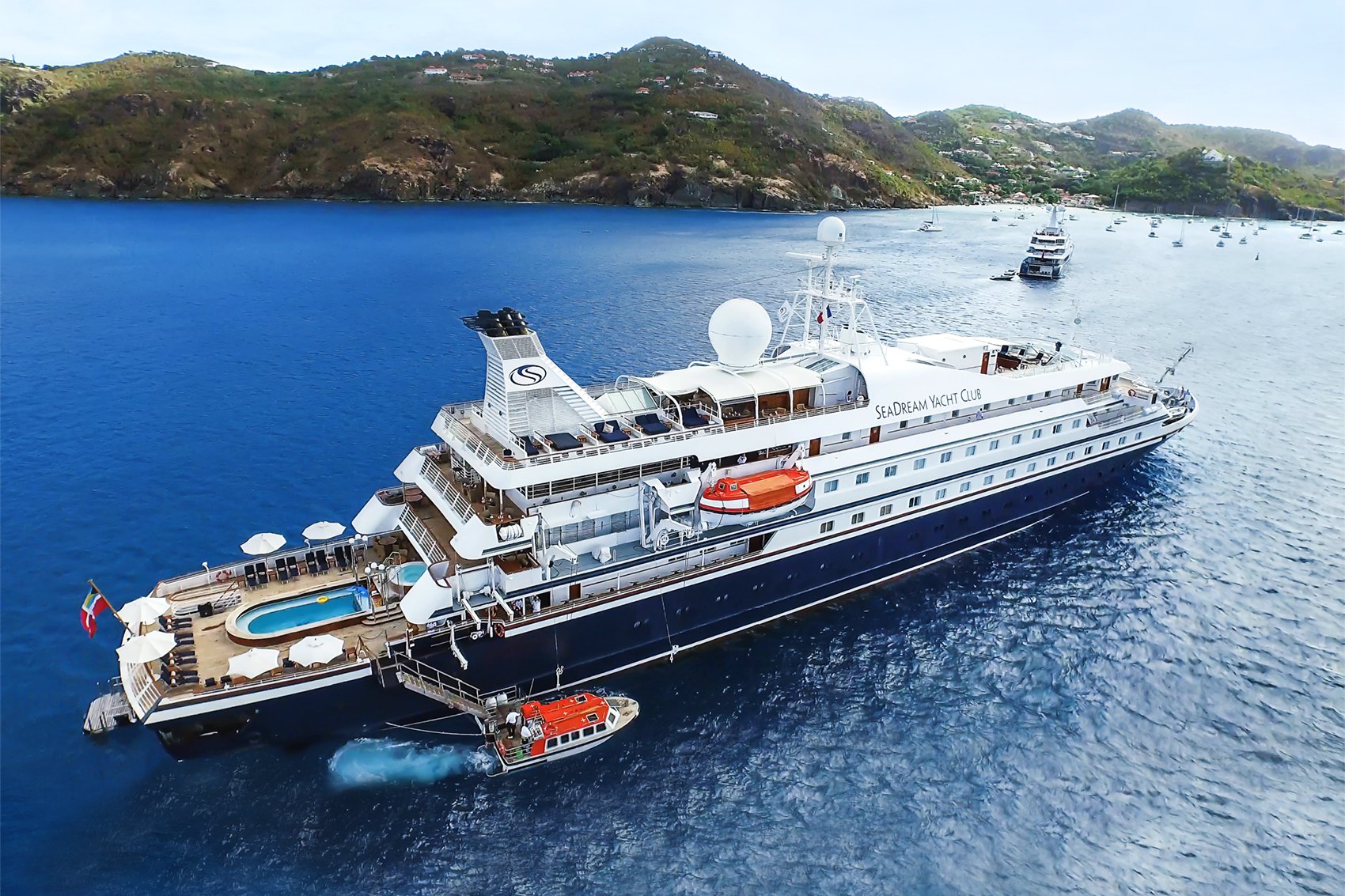 yachts_1 SeaDream yacht anchored in a picturesque Mediterranean bay with lush green hills