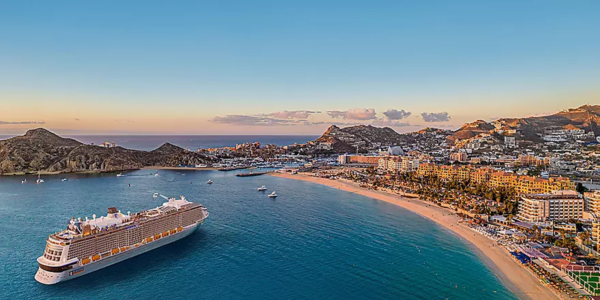 Cruise Ship at Cabo San Lucas Beach Resort A large modern cruise ship anchors in the turquoise waters of Cabo San Lucas, with the iconic rocky
