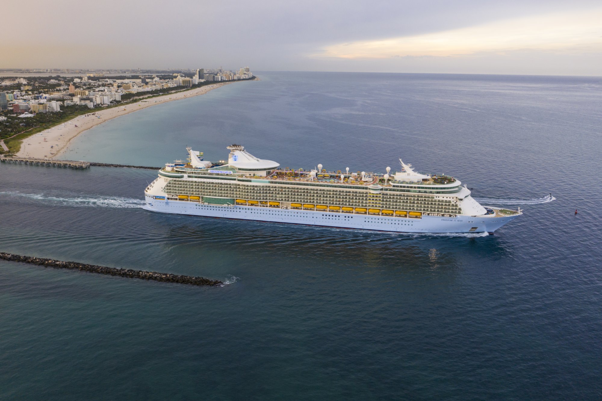 Freedom of the Seas Departing Miami Port A massive Royal Caribbean cruise ship departs from the Port of Miami, with the city's beachfront