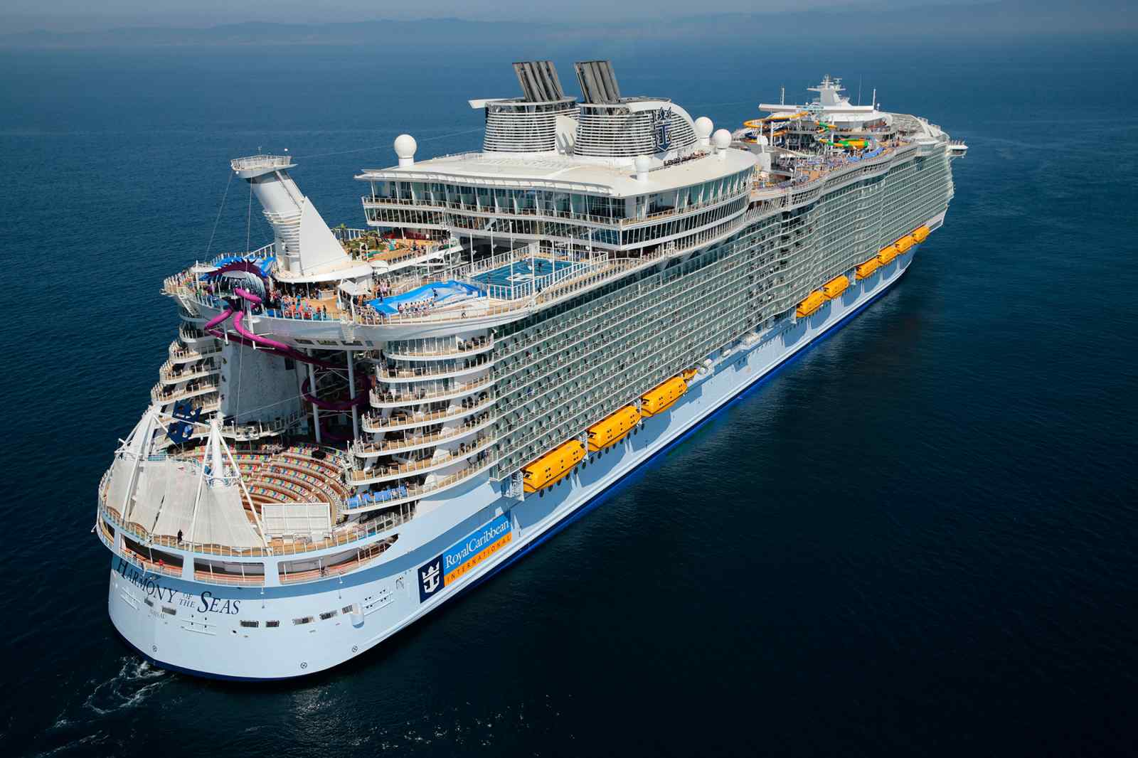 Harmony of the Seas Aerial Port View An aerial photograph of the Harmony of the Seas, a massive modern cruise ship, positioned offshore