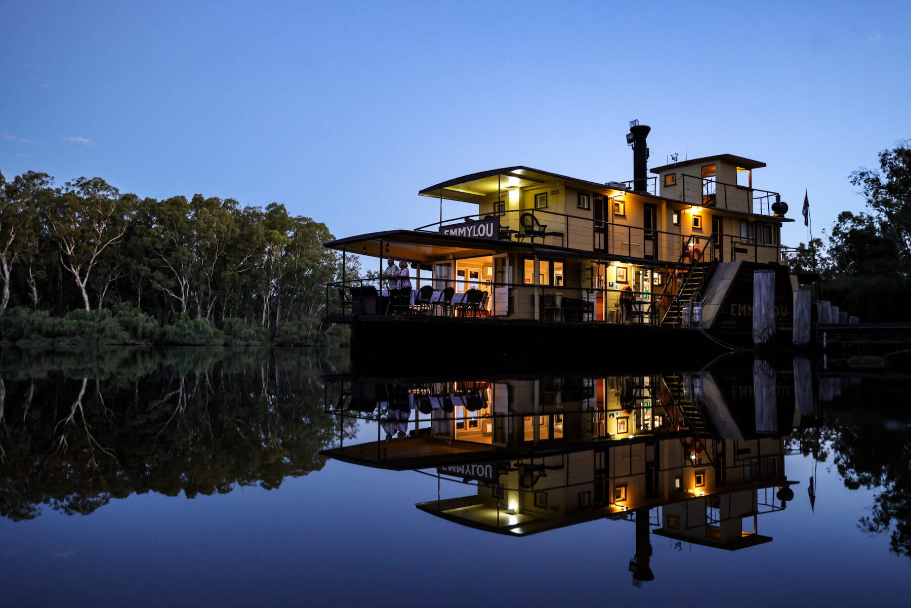 Illuminated Riverboat at Twilight with Reflections A striking nighttime image of the PS Emmylou, a heritage riverboat, beautifully lit against