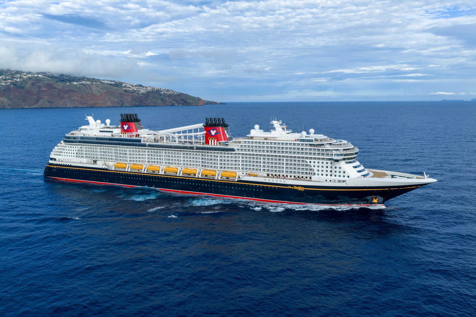 Large Cruise Ship Anchored Off Volcanic Island Disney cruise ship anchored off a volcanic island with terraced settlements