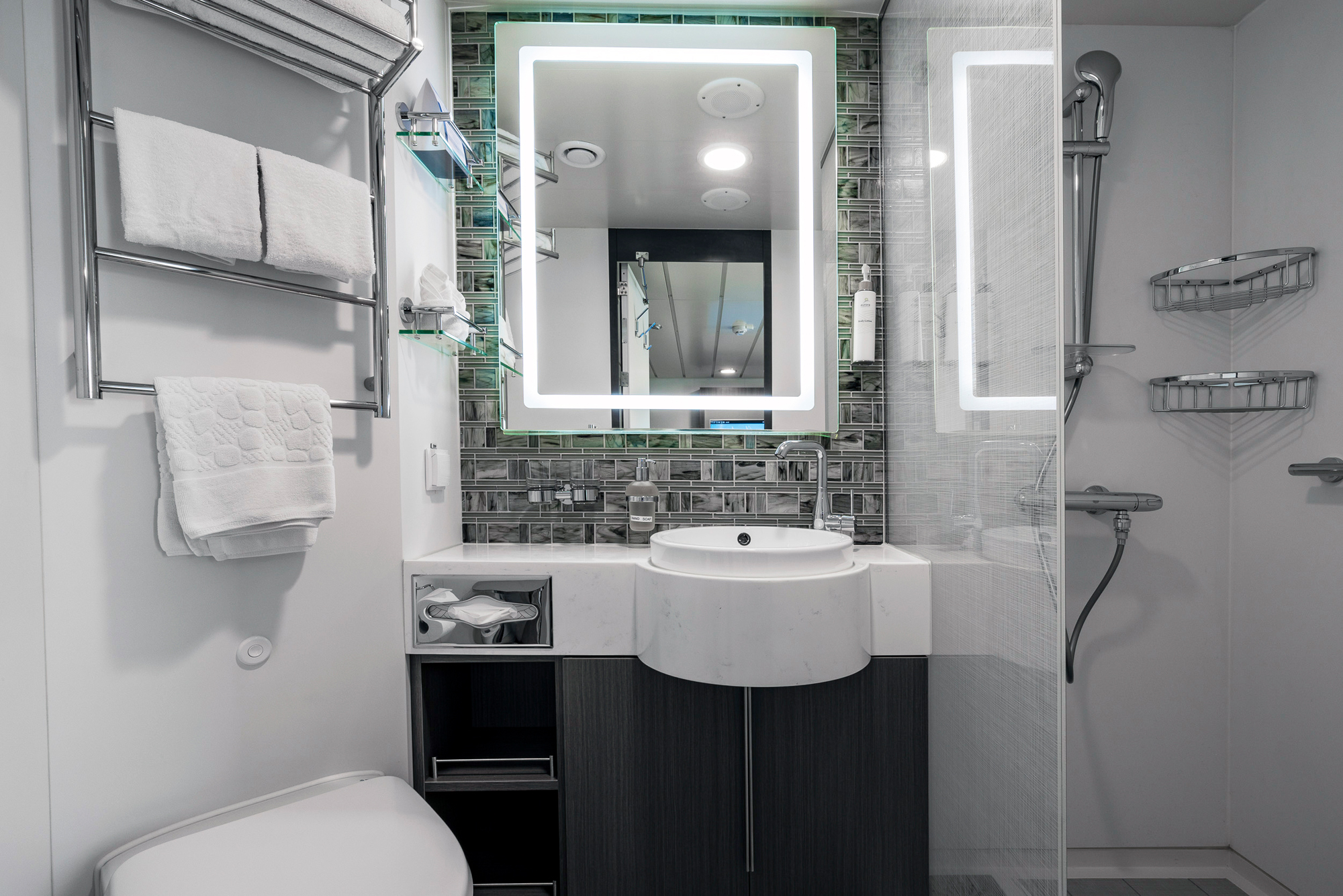 Modern Cruise Ship Bathroom with LED Mirror A contemporary bathroom aboard a cruise ship featuring a curved white sink vanity