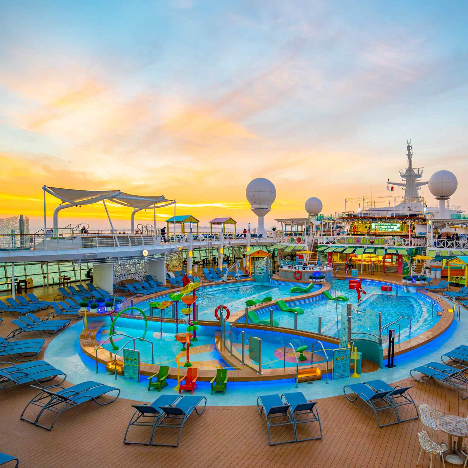 Navigator of the Seas Pool Deck at Sunset A vibrant cruise ship pool deck at golden hour, featuring multiple swimming pools with colorful