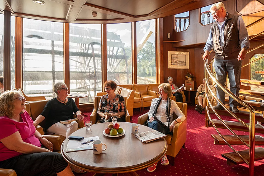 Paddlewheel Lounge Aboard River Cruise Ship An elegant lounge area aboard a river cruise ship featuring large curved windows with panoramic