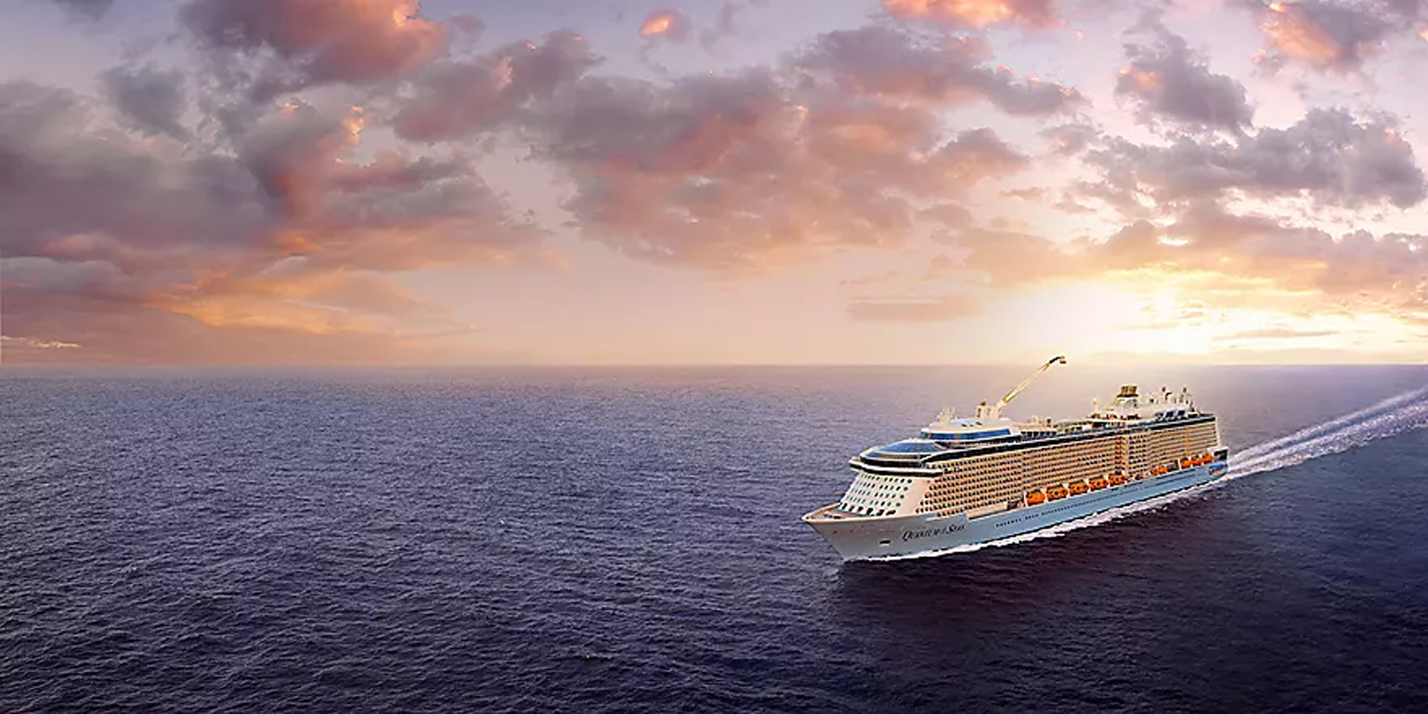 Quantum of the Seas at Sunset A massive modern cruise ship sails through calm blue waters during a stunning golden sunset