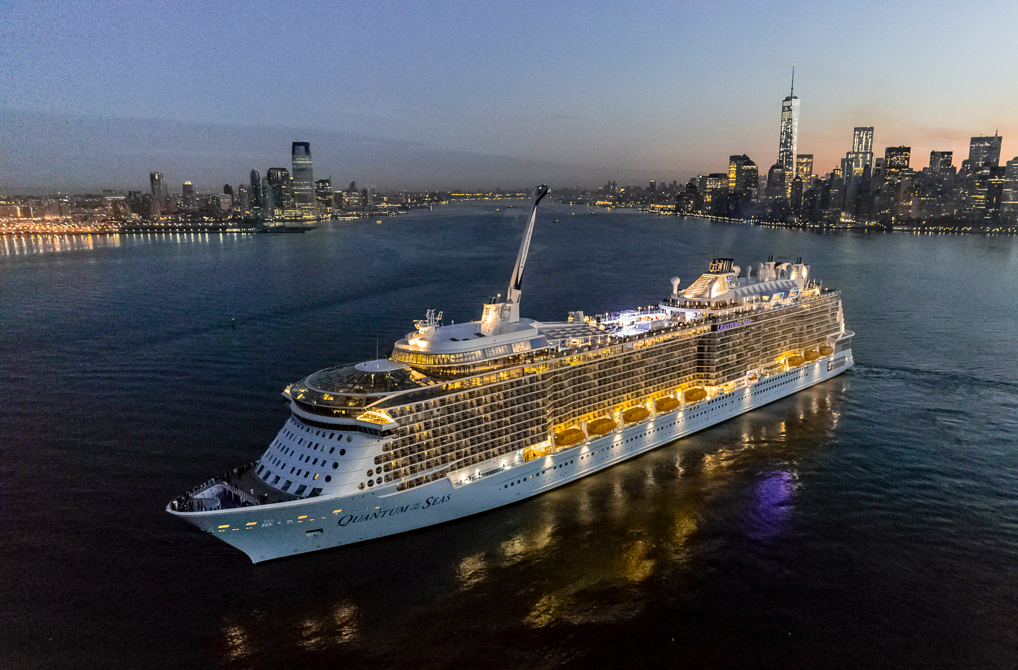 Quantum of the Seas in New York Harbor at Dusk A massive modern cruise ship illuminated against the twilight sky, anchored in New York Harbor