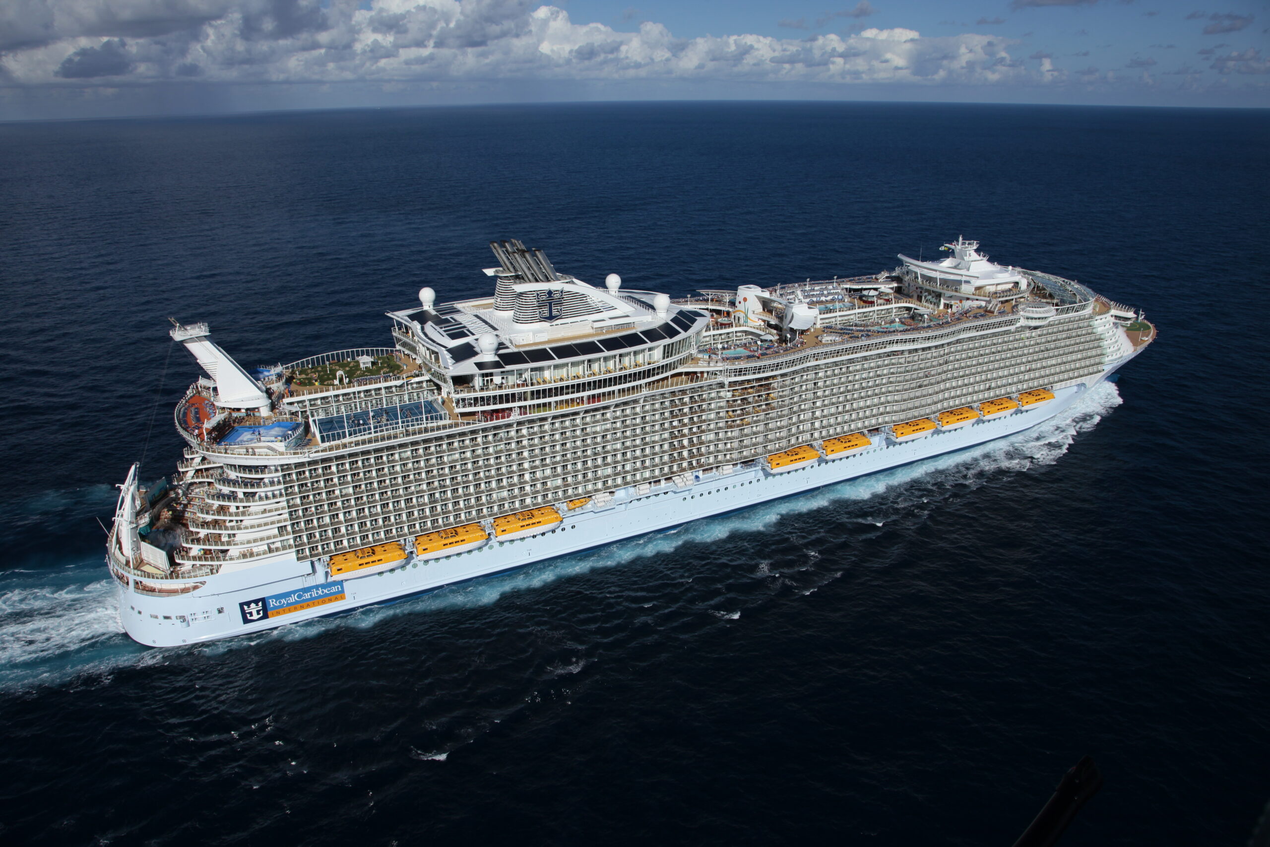 Royal Caribbean Cruise Ship at Sea An aerial view of a massive Royal Caribbean cruise ship navigating open ocean waters under partly