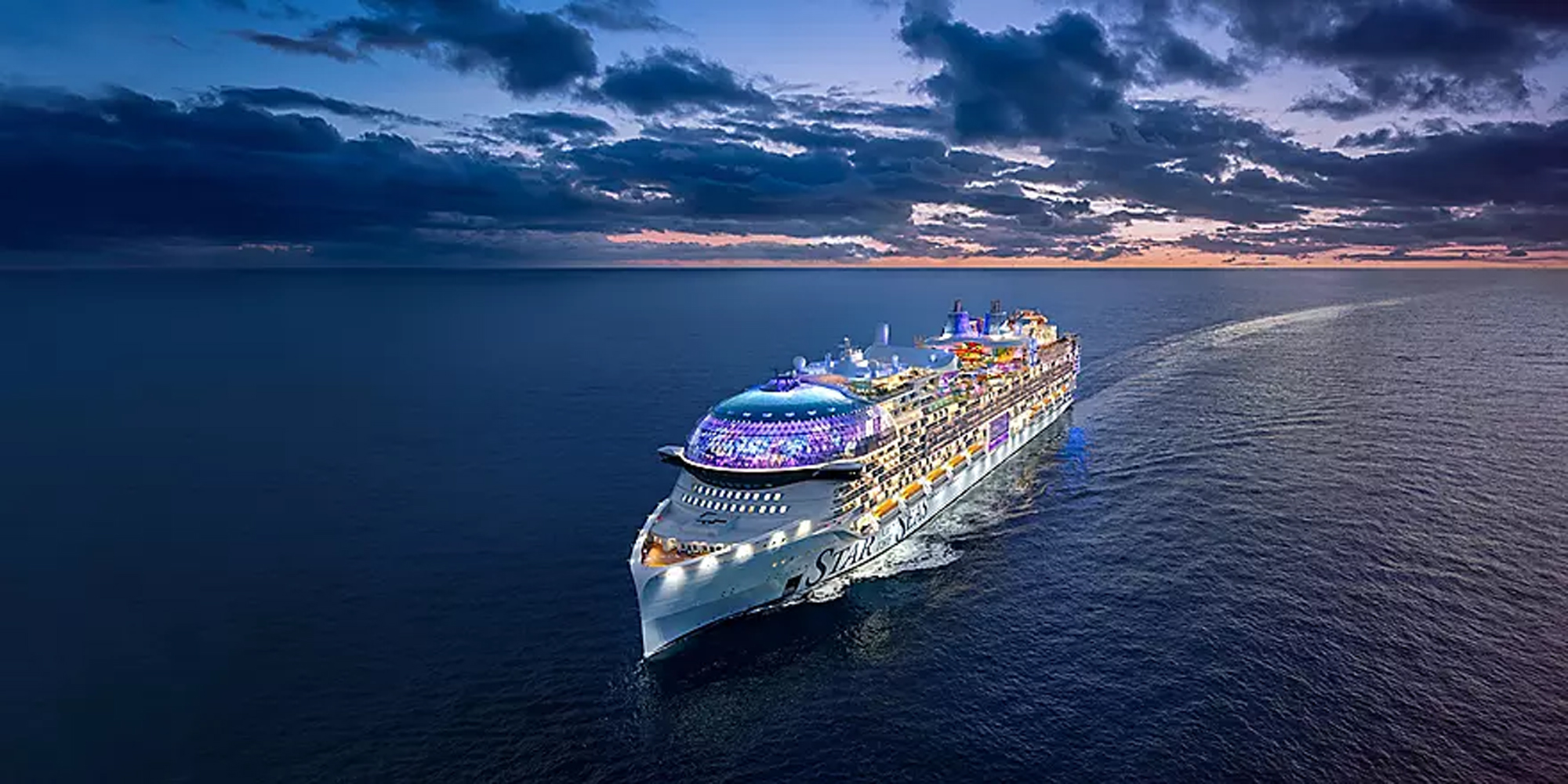 Star of the Seas Cruise Ship at Dusk An aerial photograph of a large modern cruise ship illuminated against a dramatic twilight sky