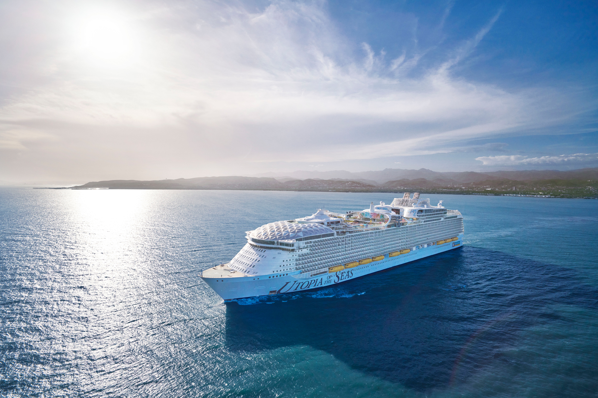 Symphony of the Seas Cruise Ship in Tropical Waters A large modern cruise ship anchored in bright blue tropical waters with a volcanic island coastline