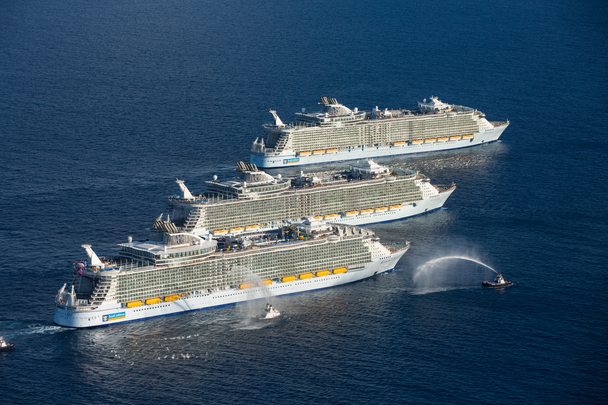 Three Royal Caribbean Sister Ships Meeting at Sea An aerial view of three massive cruise ships lined up in formation off the coast of Port