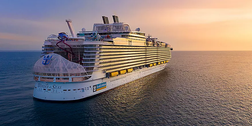 Wonder of the Seas at Sunset A massive modern cruise ship photographed from the water during golden hour, showcasing its