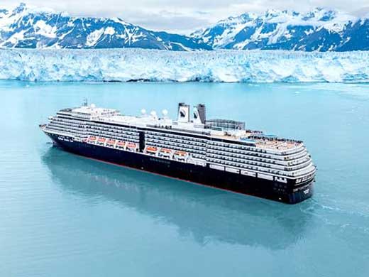 Large cruise ship in turquoise glacial waters with snow-capped mountains and glacier in background