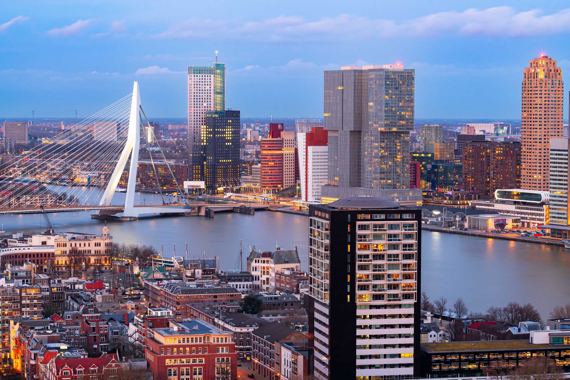 A stunning cityscape of Rotterdam, Netherlands, featuring the iconic Erasmus Bridge spanning