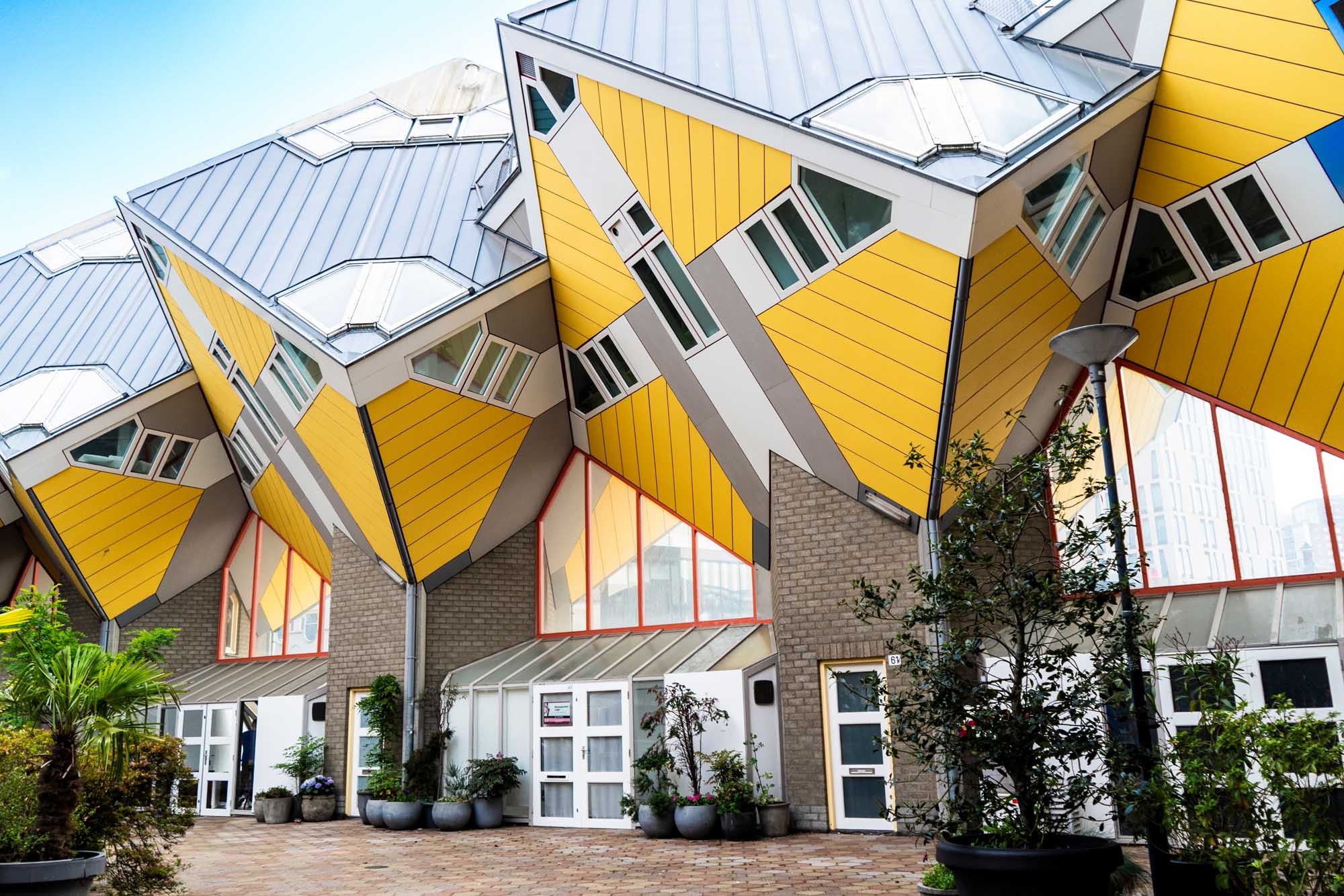 A striking architectural view of Rotterdam's iconic yellow Cube Houses (Kubuswoningen), featuring