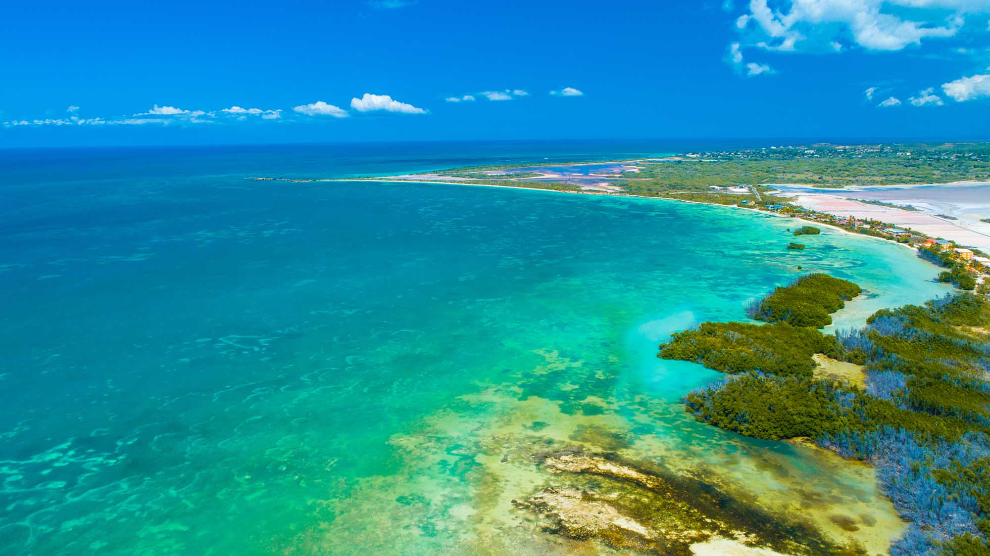 Aerial View of Puerto Rico’s Cabo Rojo Coastal Beauty An stunning aerial photograph showcasing Puerto Rico's dramatic coastline featuring Faro Los