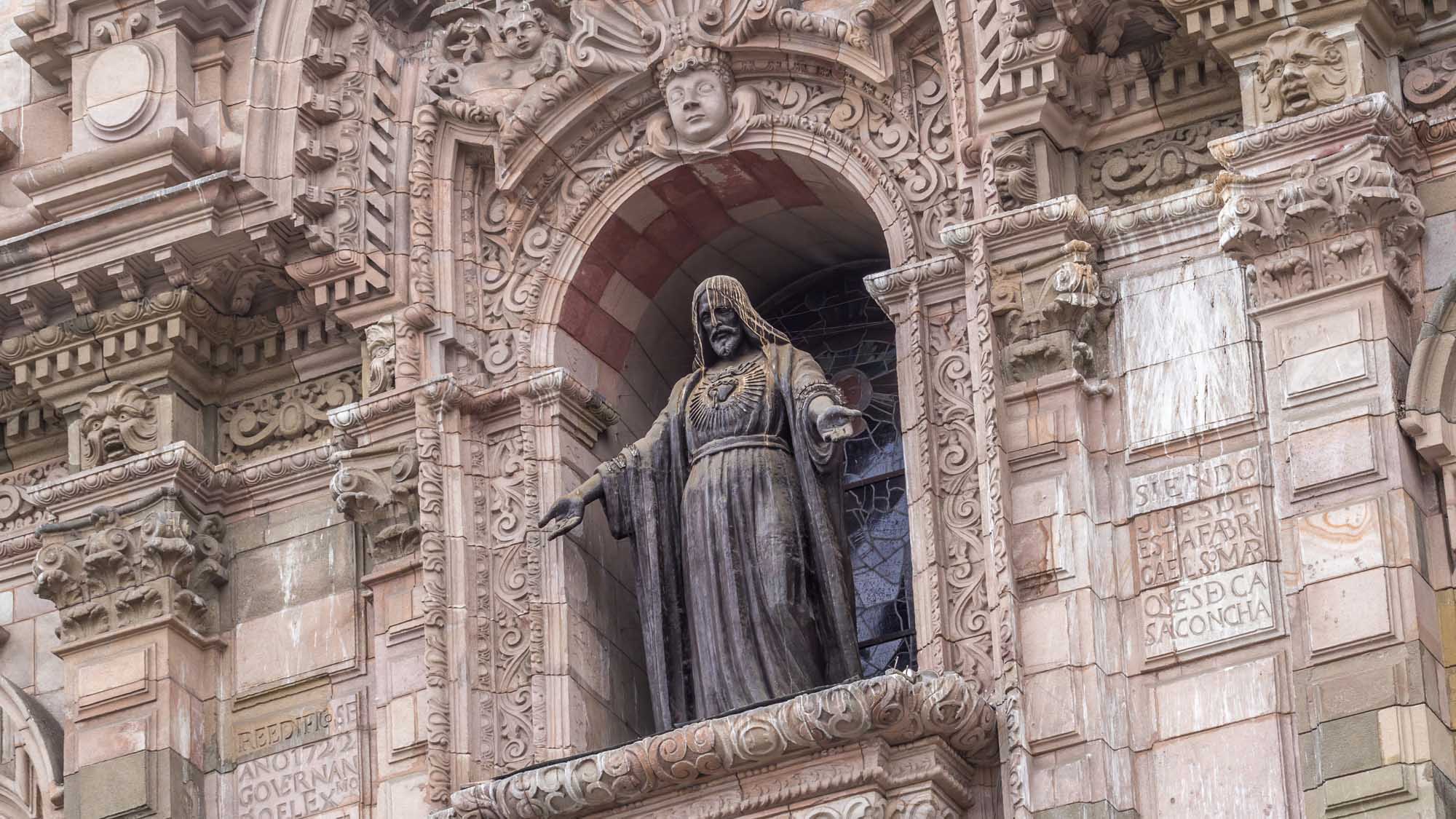 A detailed view of an ornately carved stone statue set within an elaborate Baroque architectural