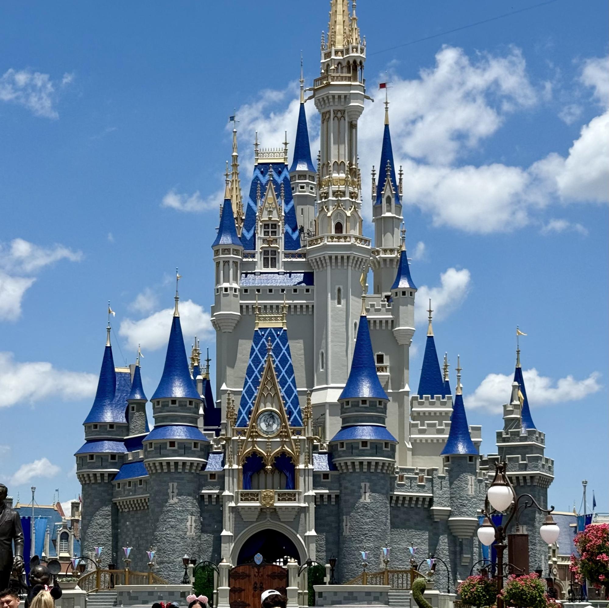 A stunning daytime photograph of Cinderella Castle, the iconic centerpiece of Magic Kingdom theme